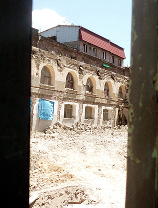 Разрушенная часть здания крытого рынка, снятая через отверстие в строительном заборе. Ереван, 28 мая 2012 г. Фото Армине Мартиросян для "Кавказского узла"