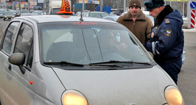 Сотрудник ДПС проверяет документы у таксиста на улицах Ставрополя. Фото http://fedpress.ru/