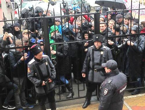 Казаки и полиция Сочи сдерживают журналистов у Адлеровского ОВД, где находятся арестованные участницы Pussy Riot. Сочи, 18 февраля 2014 г. Фото с личной страницы твиттер активистов группы Война twitter.com