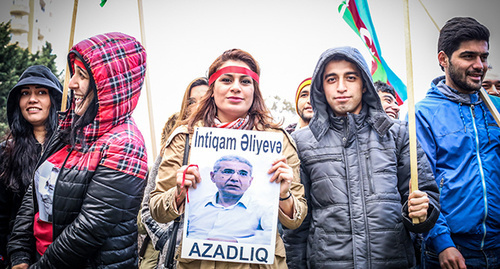 участник  акции держит в руках плокат Интигама Алиева. Фото азиза каримова для "Кавказского узла"