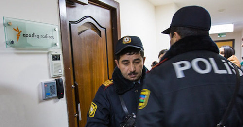 Сотрудник полиции возле двери офиса "Радио Собода". Баку, 26 декабря 2014 г. Фото корреспондента "Кавказского узла"