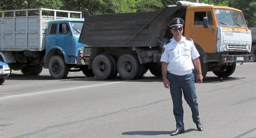 Сотрудник полиции на перекрытой грузовиками улице в Ереване. 17 июля 2016 года. Фото Тиграна Петросяна для "Кавказского узла"