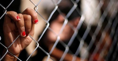 Женская рука на сетке. Ирак. Фото: REUTERS/Suhaib Salem