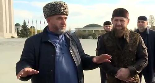 Представиль рода Нальгиевых (слева) и Рамзан Кадыров (справа) у мечети в Грозном. Кадр из новостного сюжета телекомпании "Грозный" 2 ноября 2018 года. https://www.youtube.com/watch?v=hGRTXdrqXMw