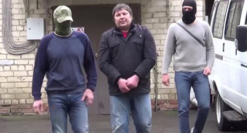 Хазвах Черхигов (в центре) задержан силовиками. Кадр из видео ФСБ России