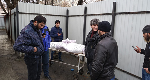 Родственники возле тела активиста Муслима Хашагульгова, убитого 12 декабря около ТЦ "Ковчег" в Назрани. 13 декабря 2018 года. Фото Умара Йовлоя для "Кавказского узла"