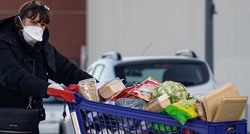 Женщина в медицинской маске с продуктами, купленными в магазине. Фото: REUTERS/Pascal Rossignol