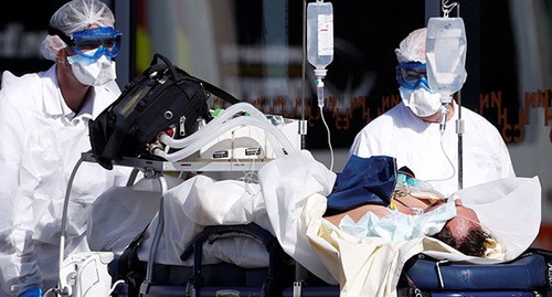 Медицинские работники везут на носилках больного, зараженного вирусом. Фото: REUTERS/Christian Hartmann