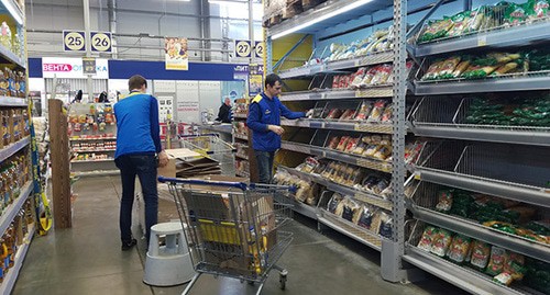 Продавцы раскладывают продукты на полки магазина. Фото Татьяны Филимоновой для "Кавказского узла"