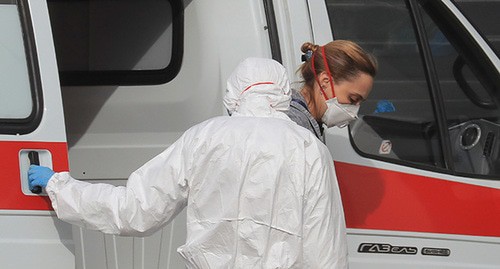 Женщина в защитной маске выходит из машины скорой помощи. Фото: REUTERS/Tatyana Makeyeva