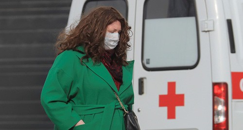Женщина в медицинской маске возле машины скорой помощи. Москва, март 2020 г. Фото: REUTERS/Tatyana Makeyeva