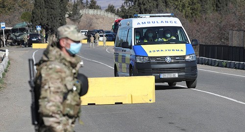 Военнослужащий Грузии в защитной маске рядом с машиной скорой помощи. Март 2020 г. Фото: REUTERS/Irakli Gedenidze