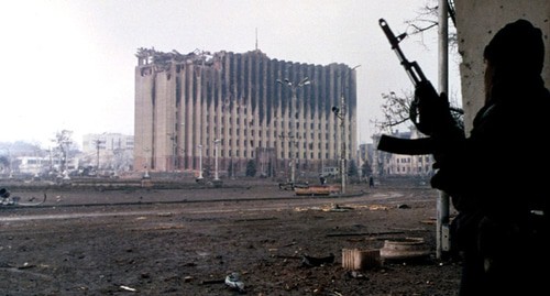Чеченский боец стоит возле здания правительственного дворца во время короткого затишья в боевых действиях в Грозном, Чечня. Фото Михаила Евстафьева