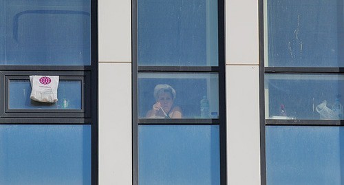 Женщина в окне здания больницы. Россия, март 2020 г. Фото: REUTERS/Maxim Shemetov