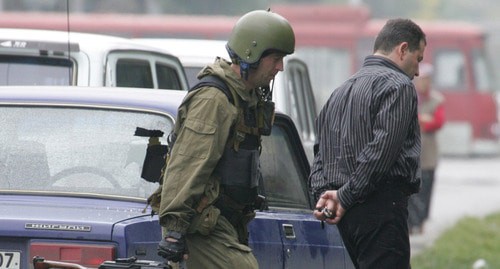 Сотрудник силовых структур ведет арестованного. Нальчик, 14 октября 2005 г. Фото: REUTERS/Viktor Korotayev