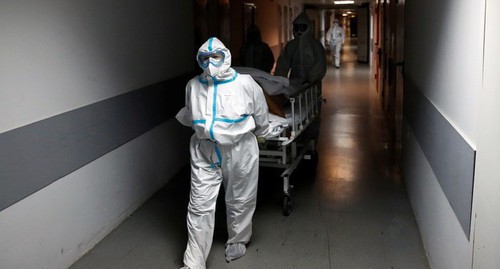 Медперсонал с пациентом в больничном коридоре. Фото REUTERS/Maxim Shemetov