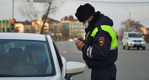 Сотрудник полиции проверяет документы у водителя. Фото: REUTERS/Ramzan Musaev