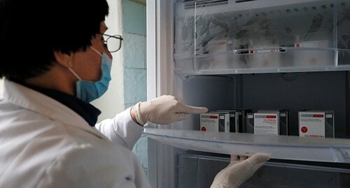 Медицинский работник указывает на упаковки с вакциной от COVID-19. Фото: REUTERS/Alexander Ermochenko