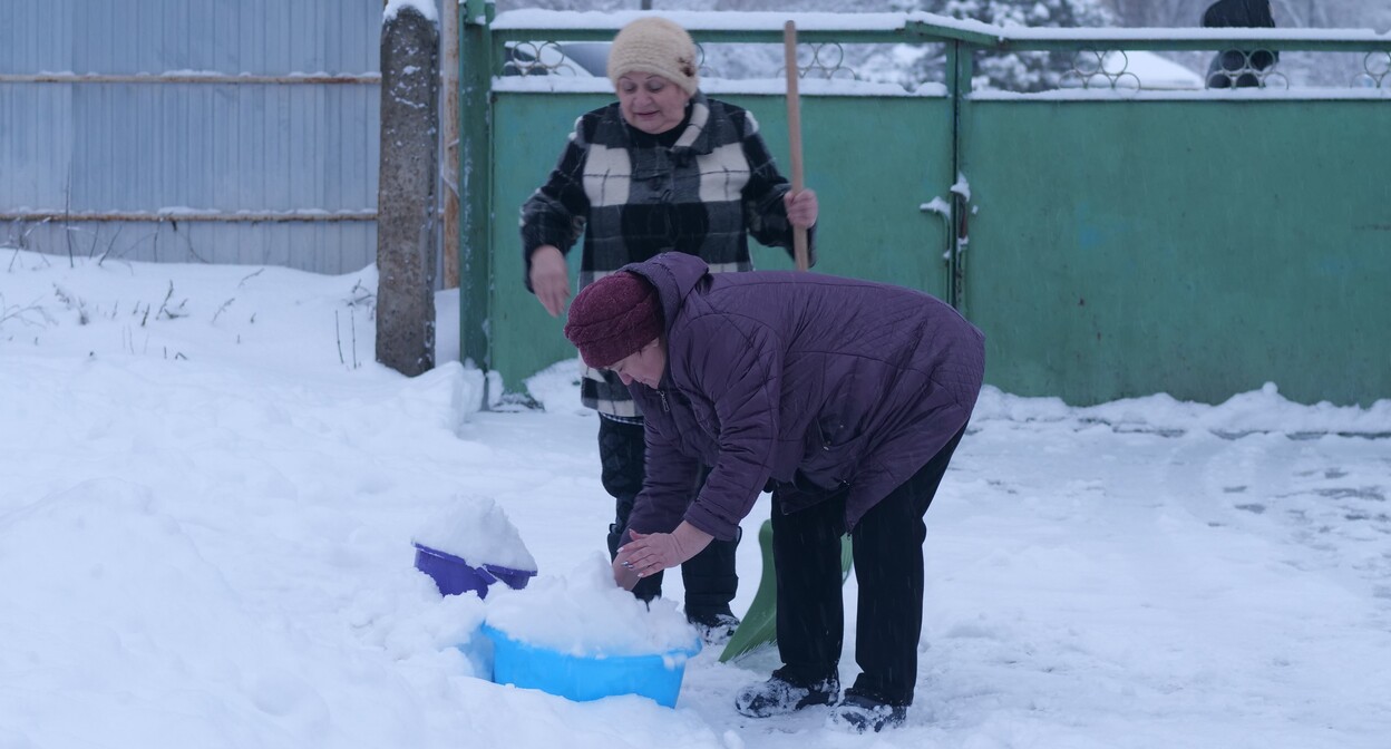 Жители Красного Сулина собирают снег, чтобы растапливать его в отсутствие водоснабжения. 26 декабря 2021 года. Фото Сергея Снежина для "Кавказского узла".