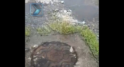 Вода из-под канализационного люка заливает улицу Кодоева в Алагире. Кадр видео из Telegram-канала "Крылья TV" https://t.me/krilyatv/7966