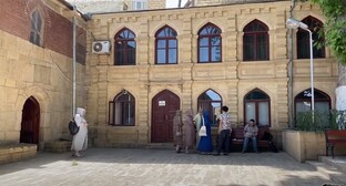 Туристы во дворе мечети в Дербенте. Стопкадр из видео https://www.youtube.com/watch?v=1rUg3LrF6kQ