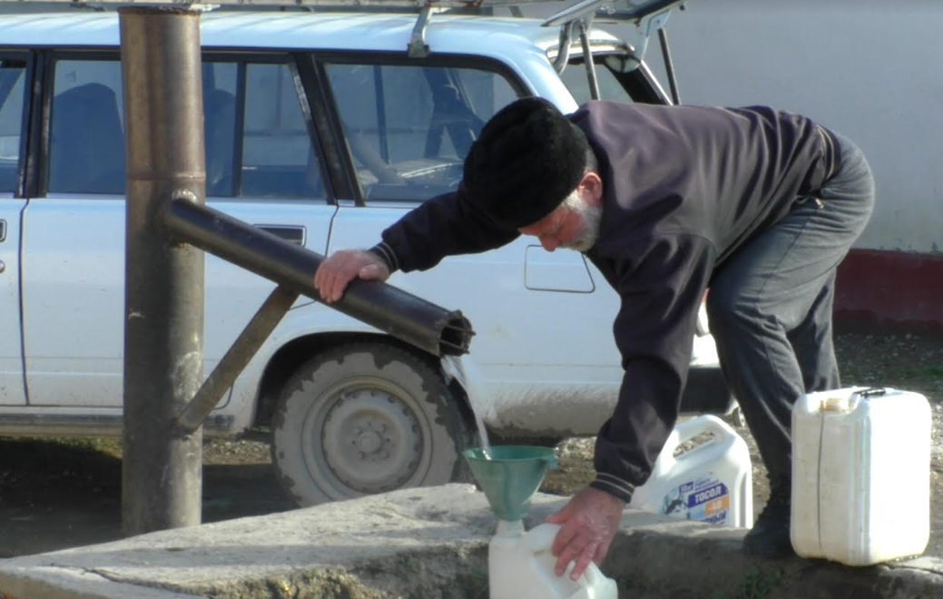 Житель Умашаула набирает воду. Стоп-кадр видео "Кавказского узла", https://youtu.be/X45ODib0-Mg
