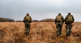 Военные идут по полю. Иллюстрация создана «Кавказским узлом» с помощью ИИ в программе Photoshop 