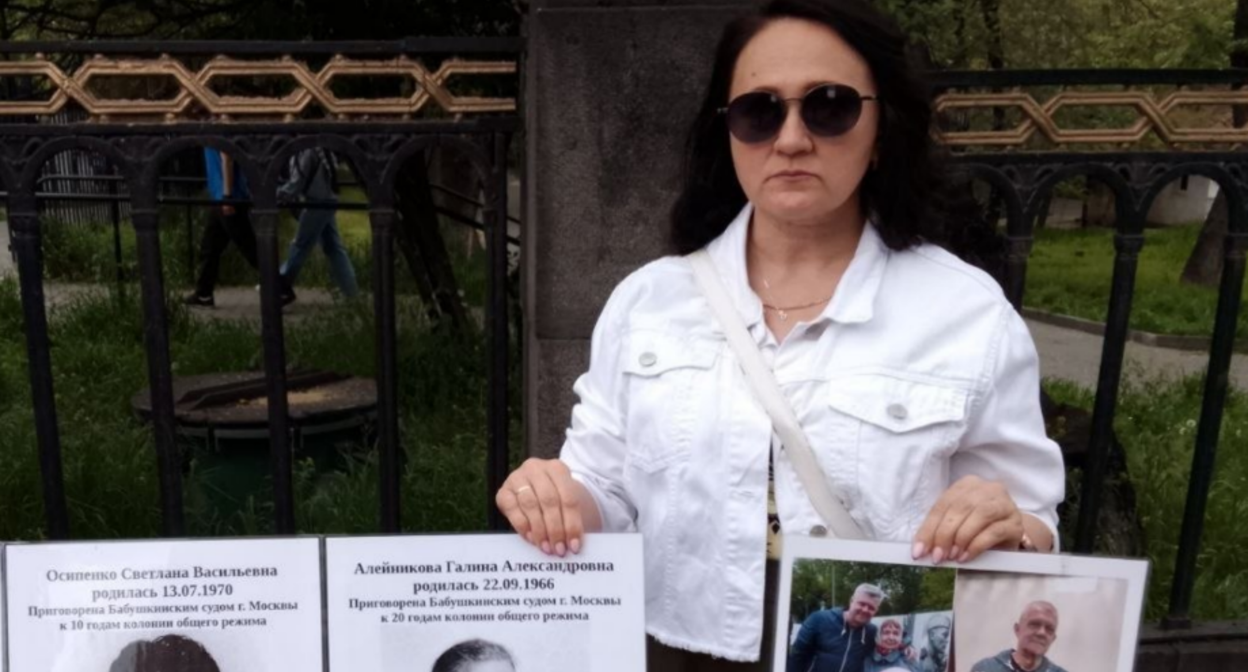 Участница пикета держит в руках плакаты. Скриншот фото RusNews от 02.05.26, https://t.me/rusnews/84132. Участница пикета держит в руках плакаты. Скриншот фото RusNews от 02.05.26, https://t.me/rusnews/84132.