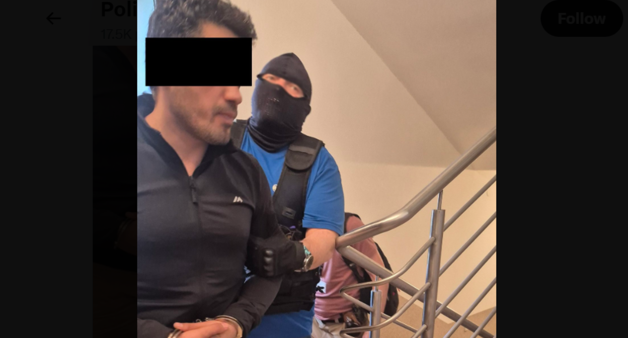 Силовик ведет Эльнура А. Скриншот фото полиции Люблина от 20.06.26, https://x.com/PolicjaLubelska/status/2068301027225292818/photo/1. Силовик ведет Эльнура А. Скриншот фото полиции Люблина от 20.06.26, https://x.com/PolicjaLubelska/status/2068301027225292818/photo/1.