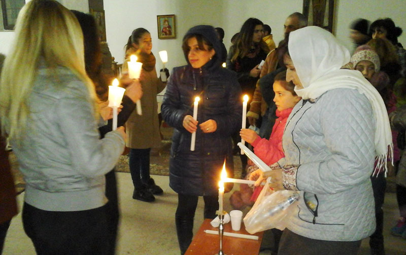 Верующие несут к себе домой зажжённые в церкви свечи.